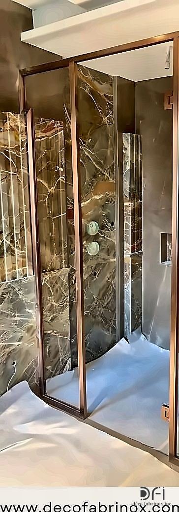 Brass shower partition set into a marble bathroom