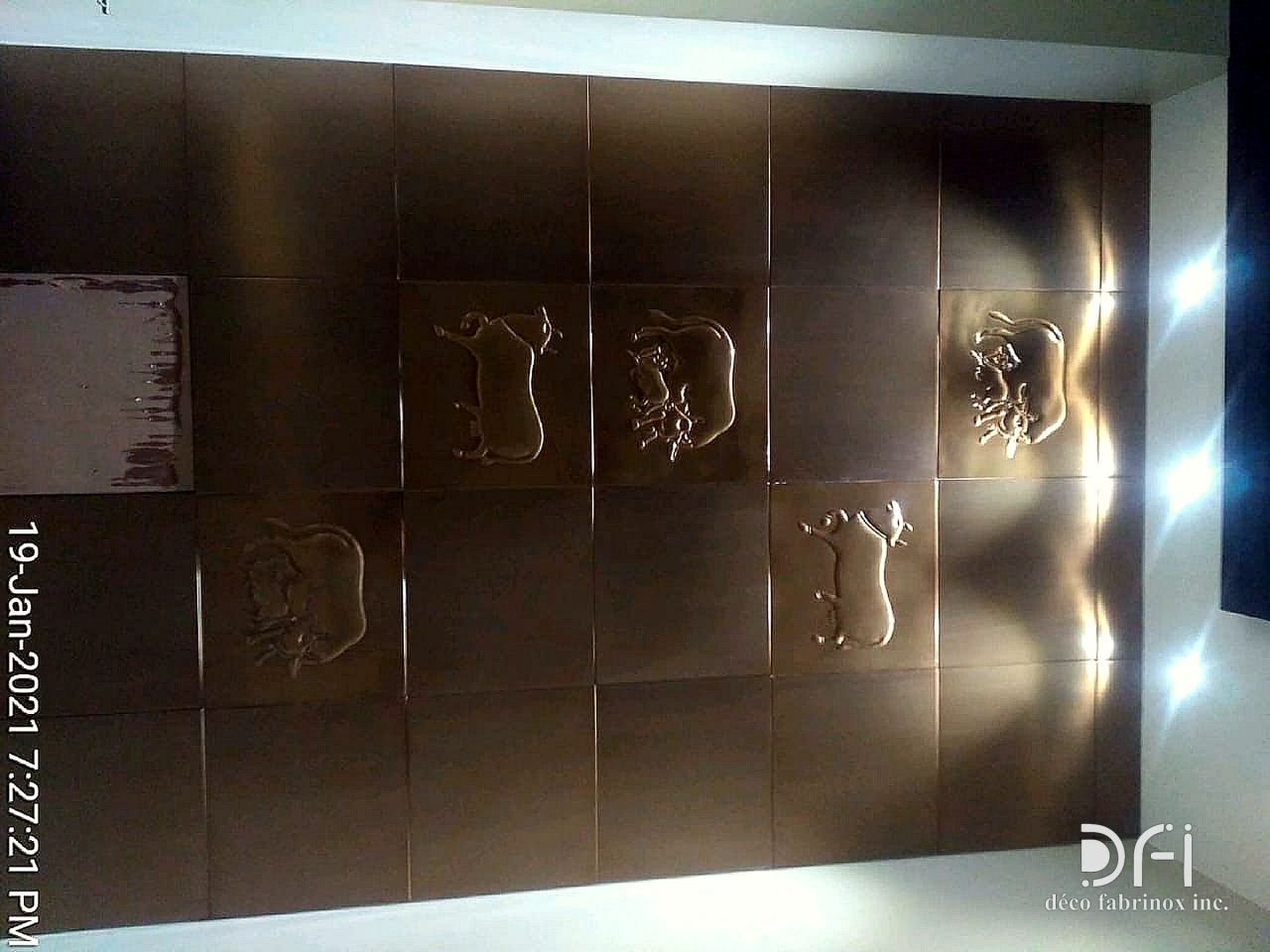 Bronze relief tile wall with raised motifs