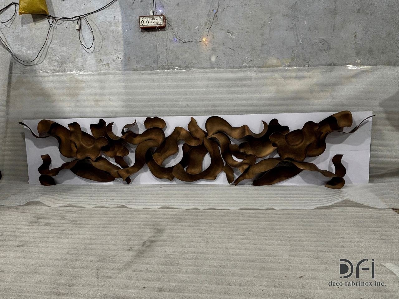 Full length of a bronze ribbon wall sculpture