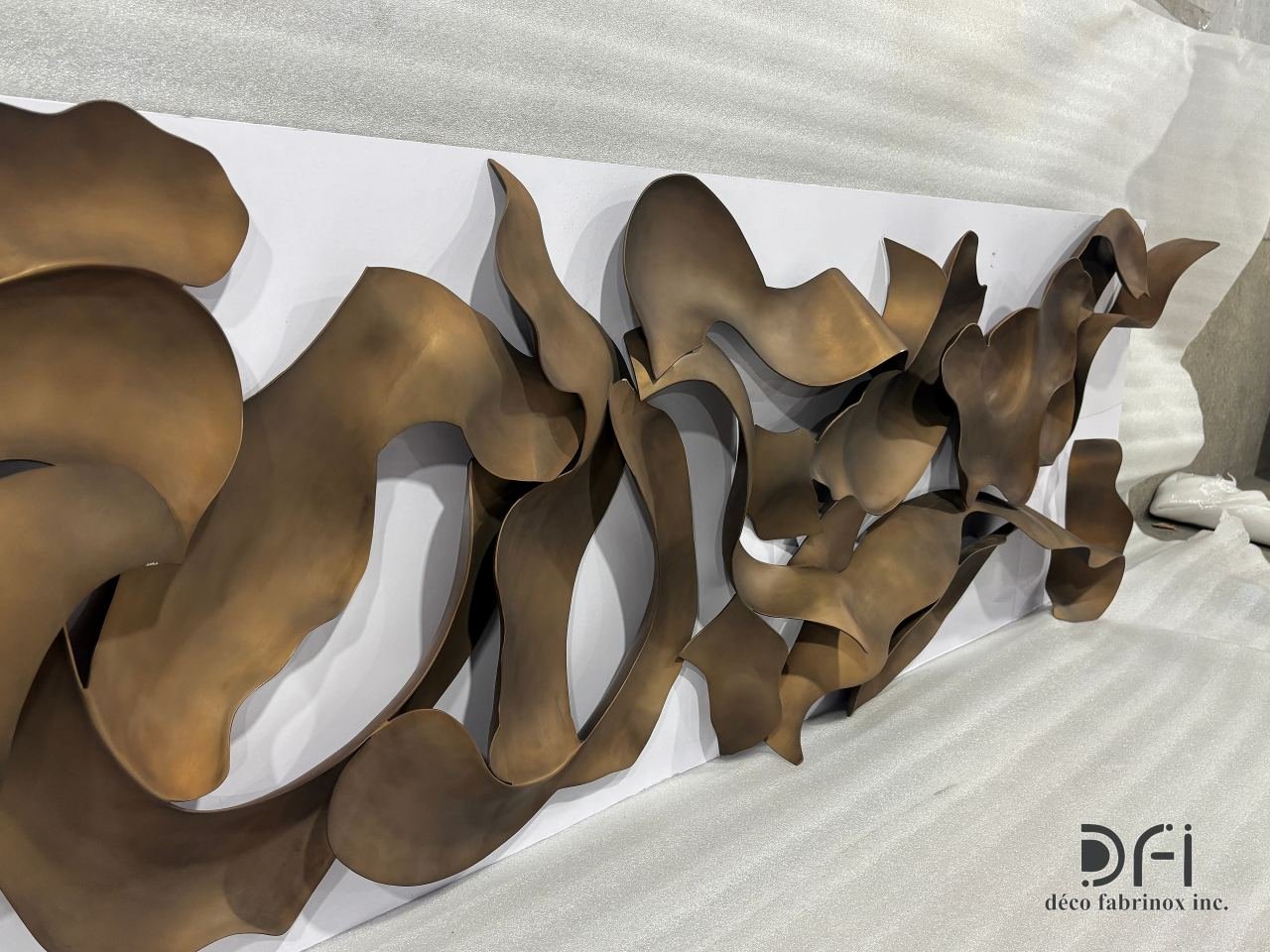 Flowing bronze ribbon wall sculpture