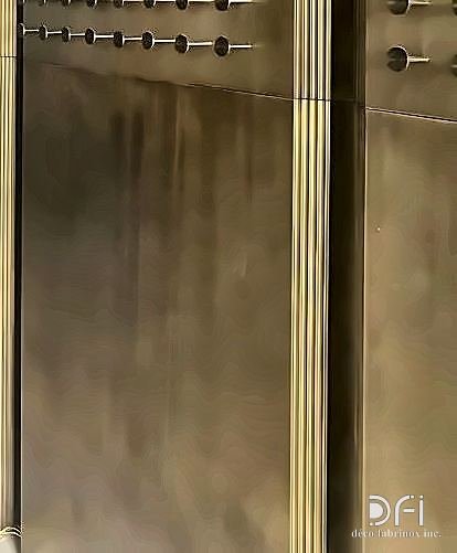 Brushed brass wall cladding in a lift lobby