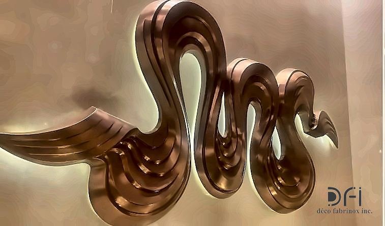 Polished copper wave sculpture mounted on a wall
