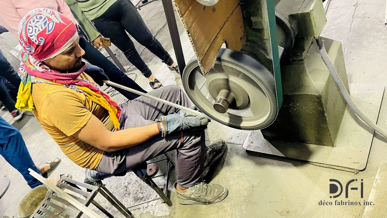 Craftsman finishing a metal part on the belt grinder