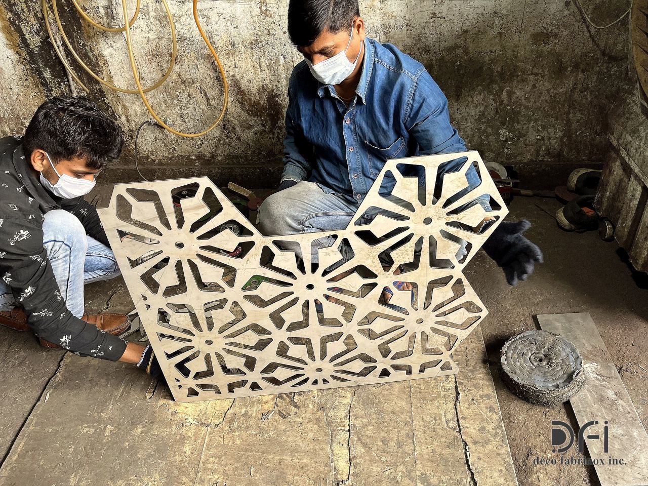 Craftsmen finishing a laser-cut geometric screen