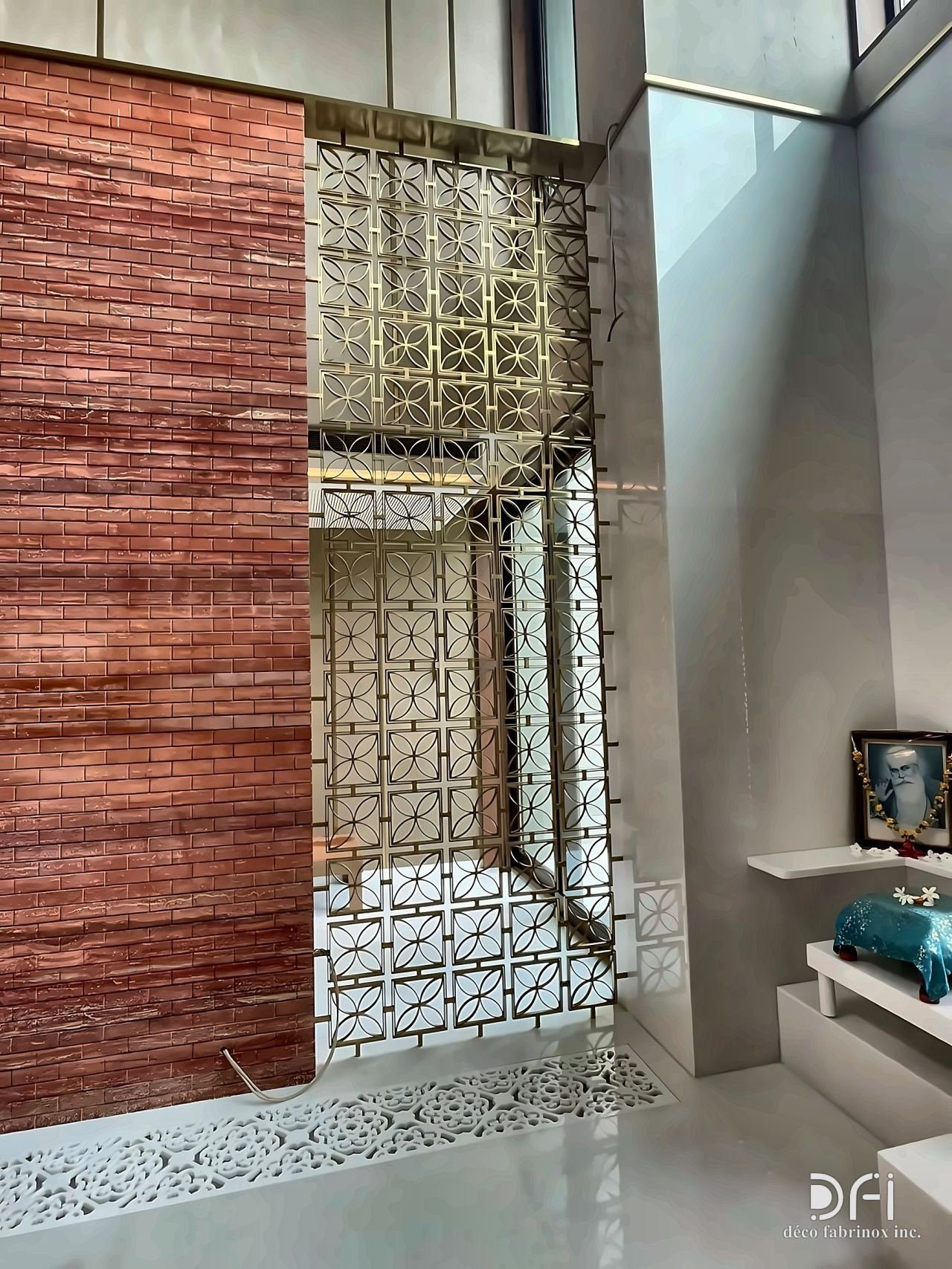 Laser-cut brass screen beside a timber-textured wall
