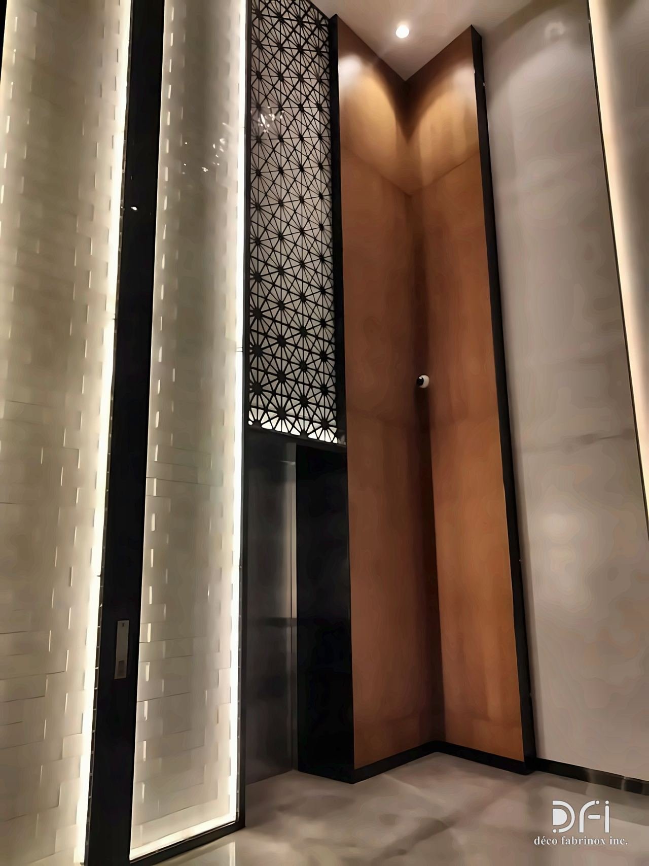Laser-cut metal panel set into a lit lobby wall
