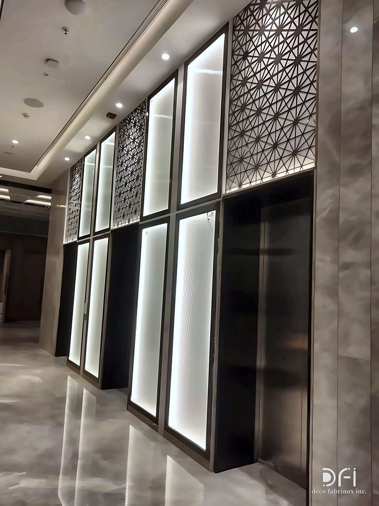 Backlit laser-cut screens along a lobby wall
