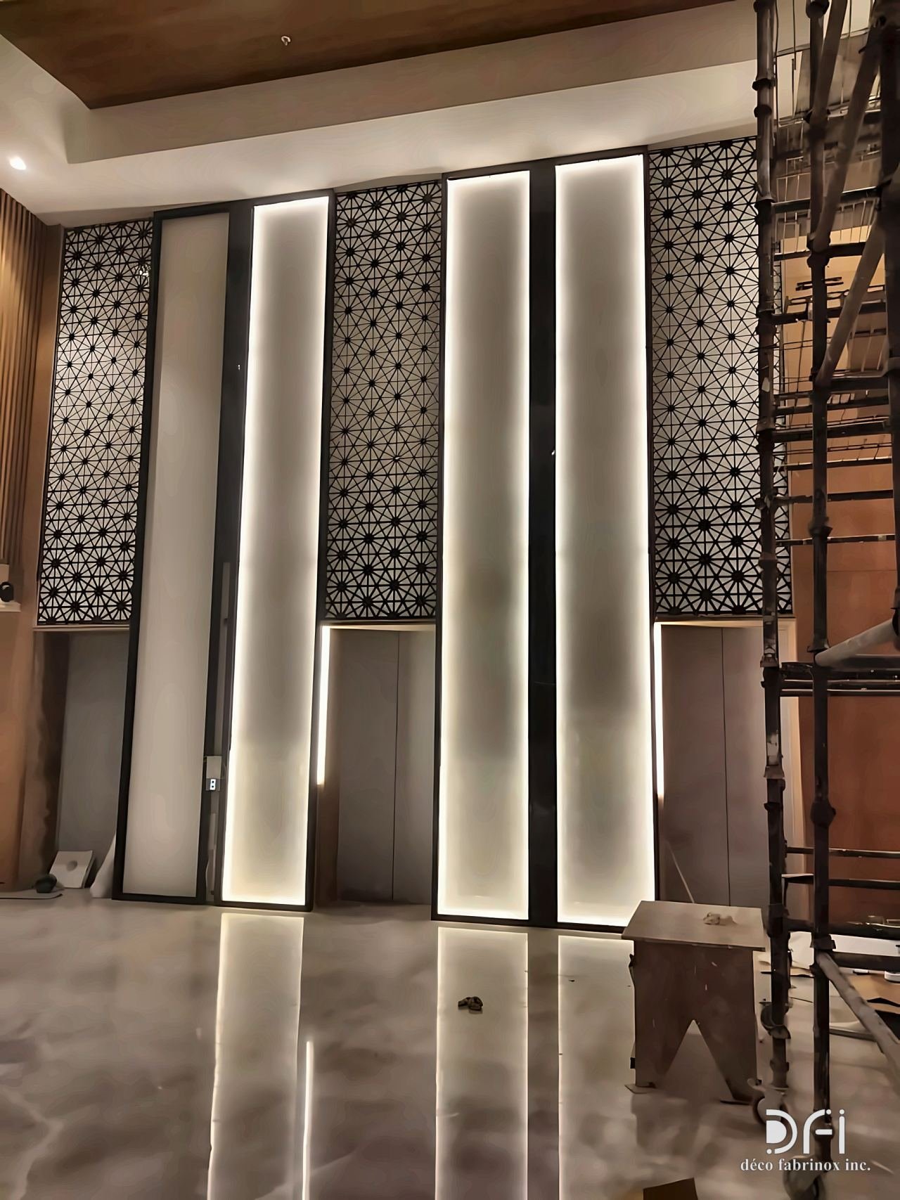 Backlit laser-cut panels and light slots on a lobby wall
