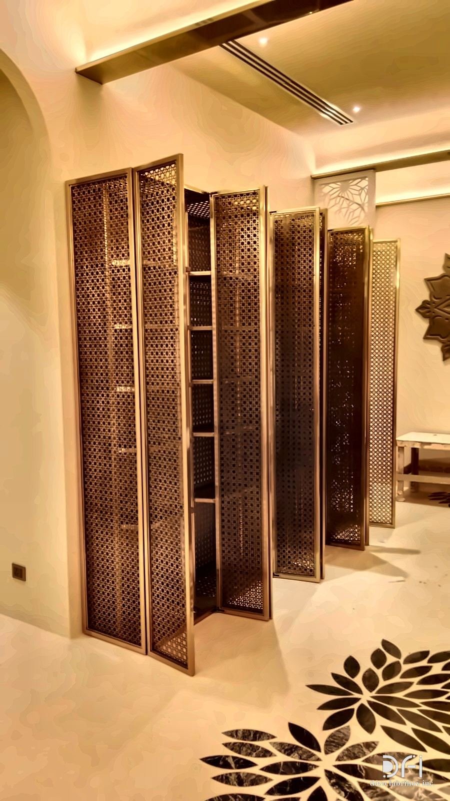 Folding bronze lattice screens in an arched room