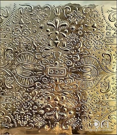 Embossed brass panel with an ornamental pattern