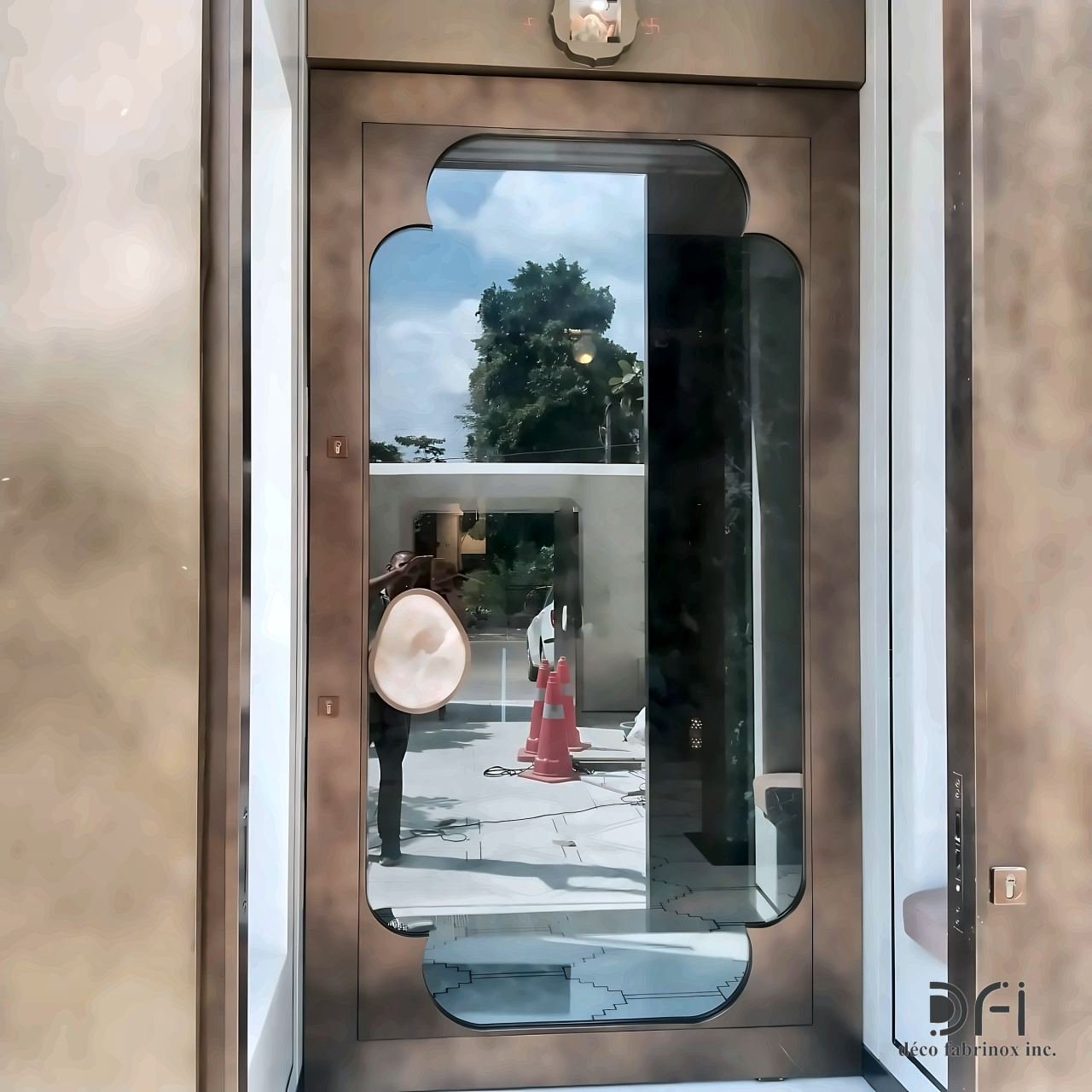 Bronze door with a cusped arch glass panel