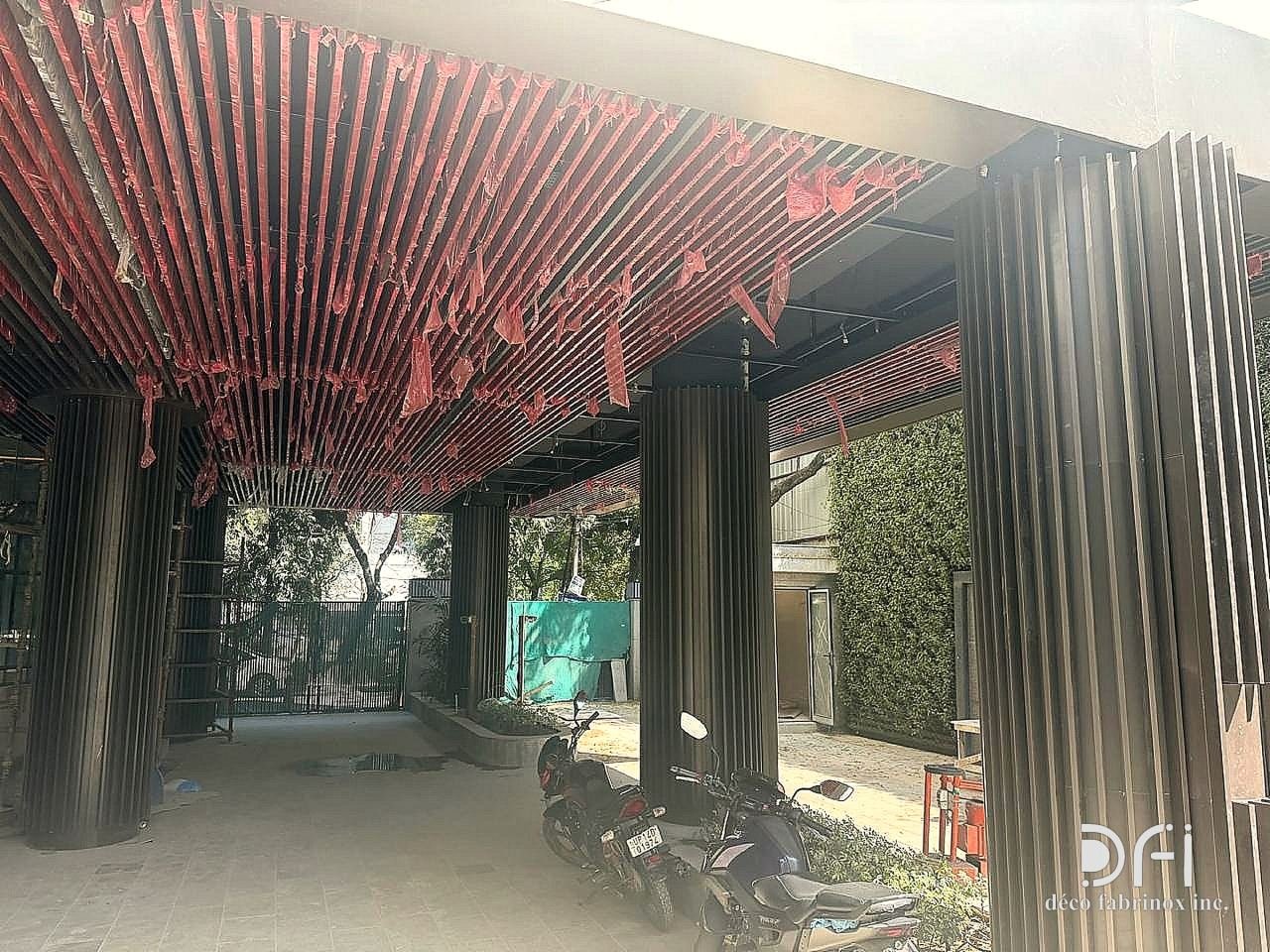 Hotel entrance canopy with a red slatted ceiling and fluted metal column