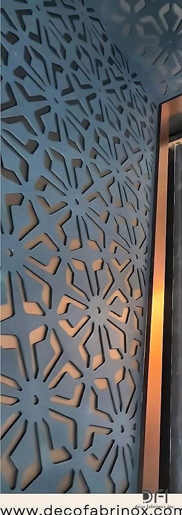 Blue laser-cut metal screen panel set against a wall