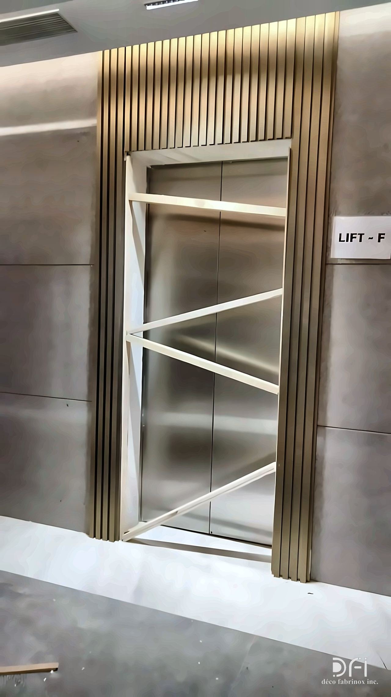 Brass fluted surround on a lift entrance