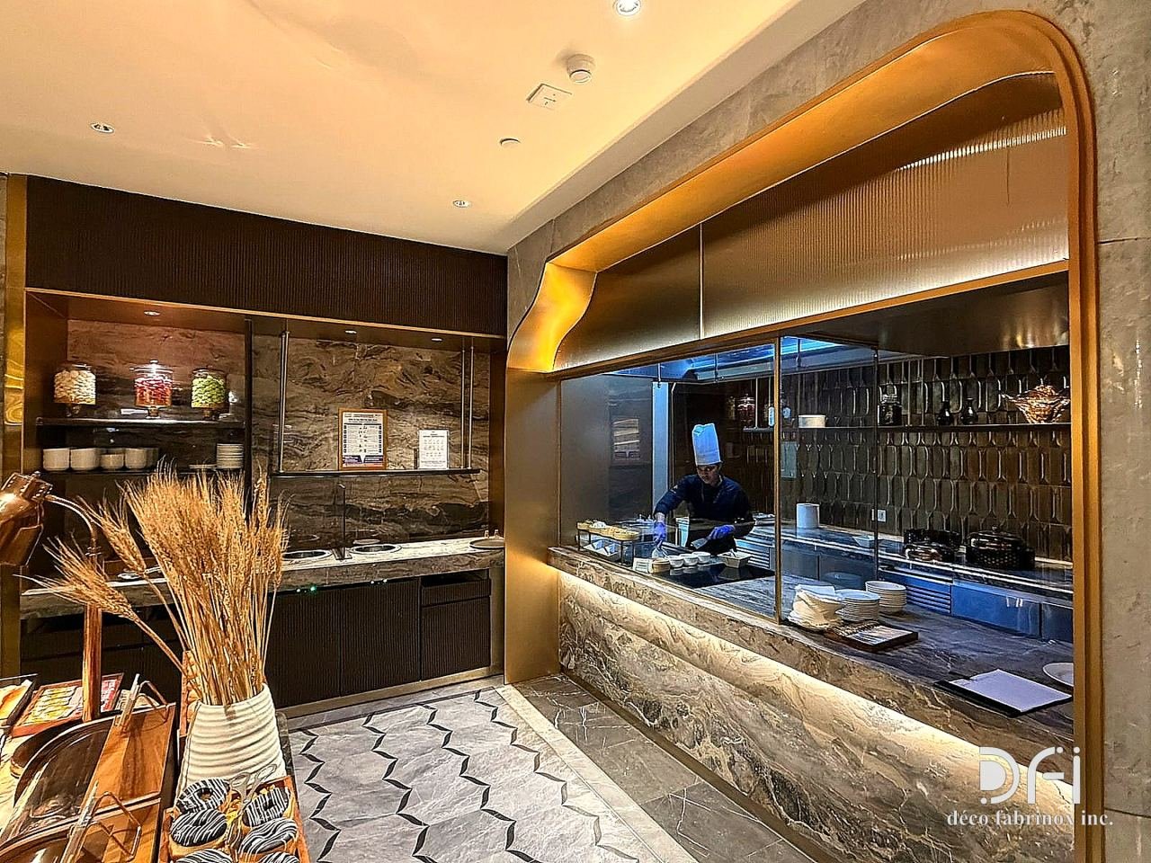 Live counter framed by a curved brass canopy in an airport lounge