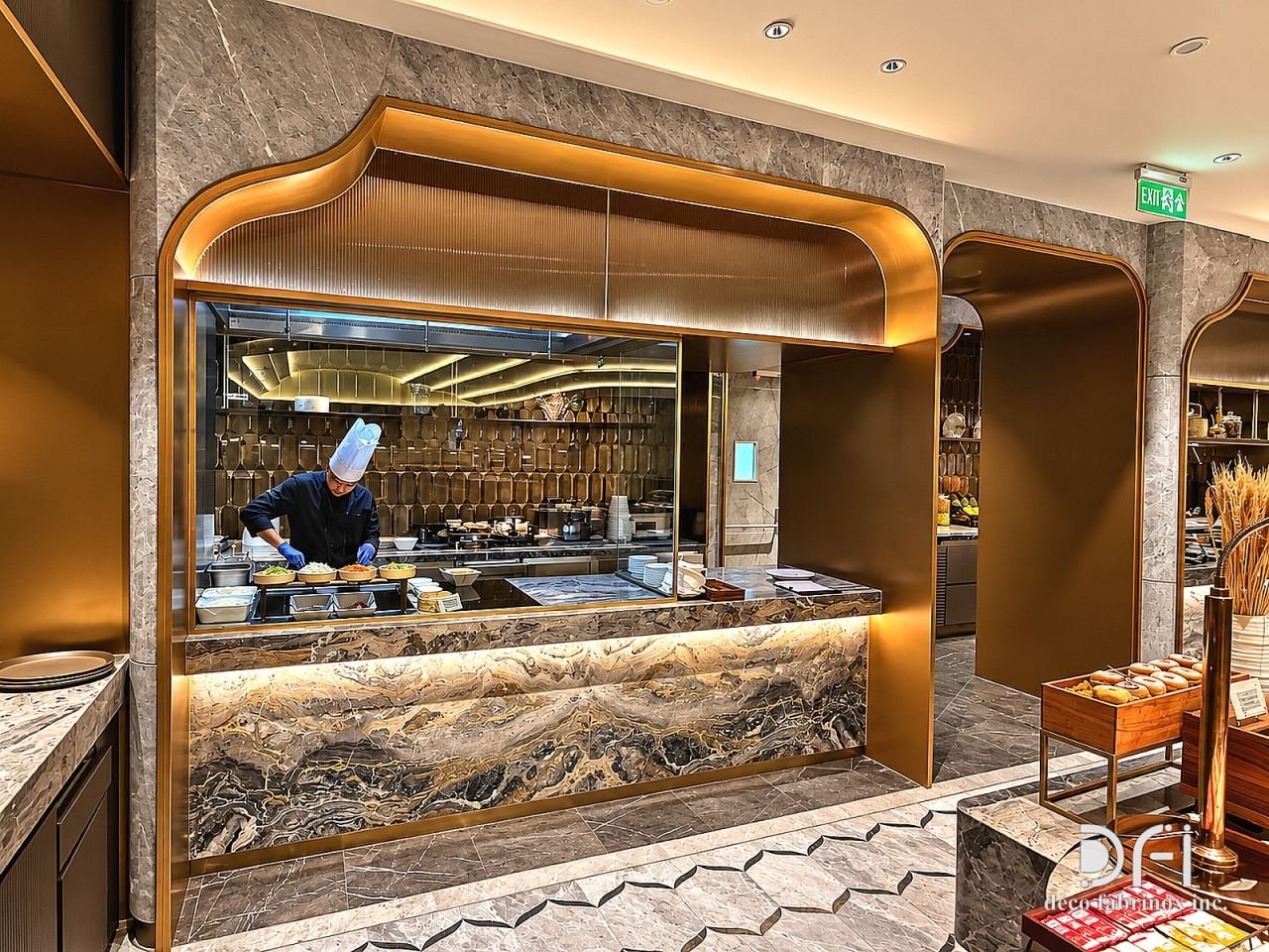Live kitchen counter under a curved brass canopy