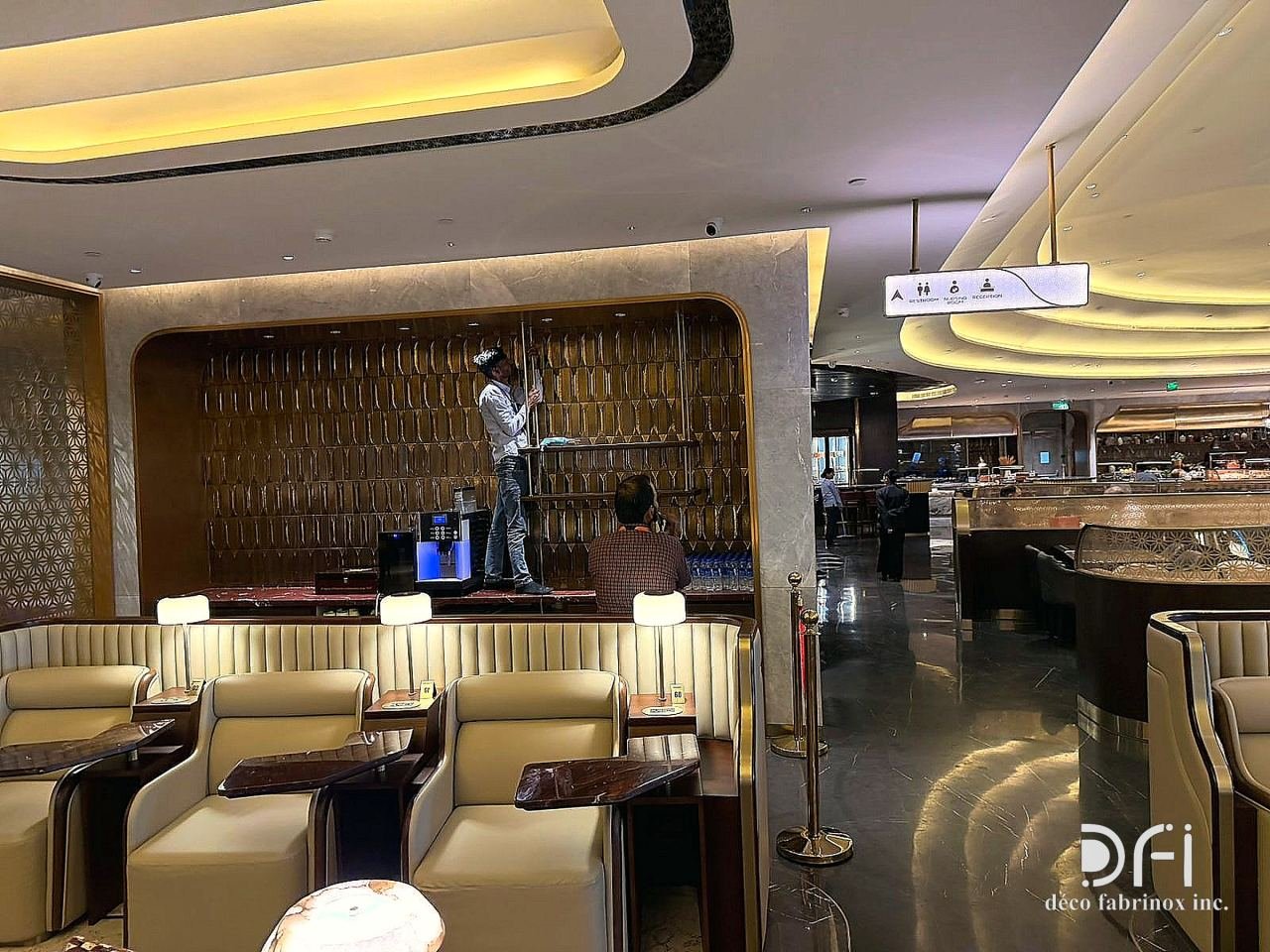 Lounge seating before a metal-framed feature wall in an airport lounge