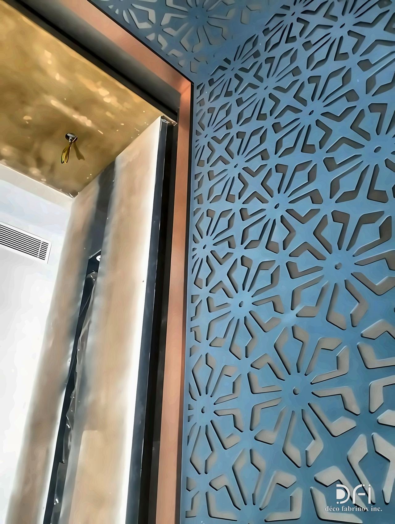 Laser-cut geometric wall panels framing a brass-lined opening