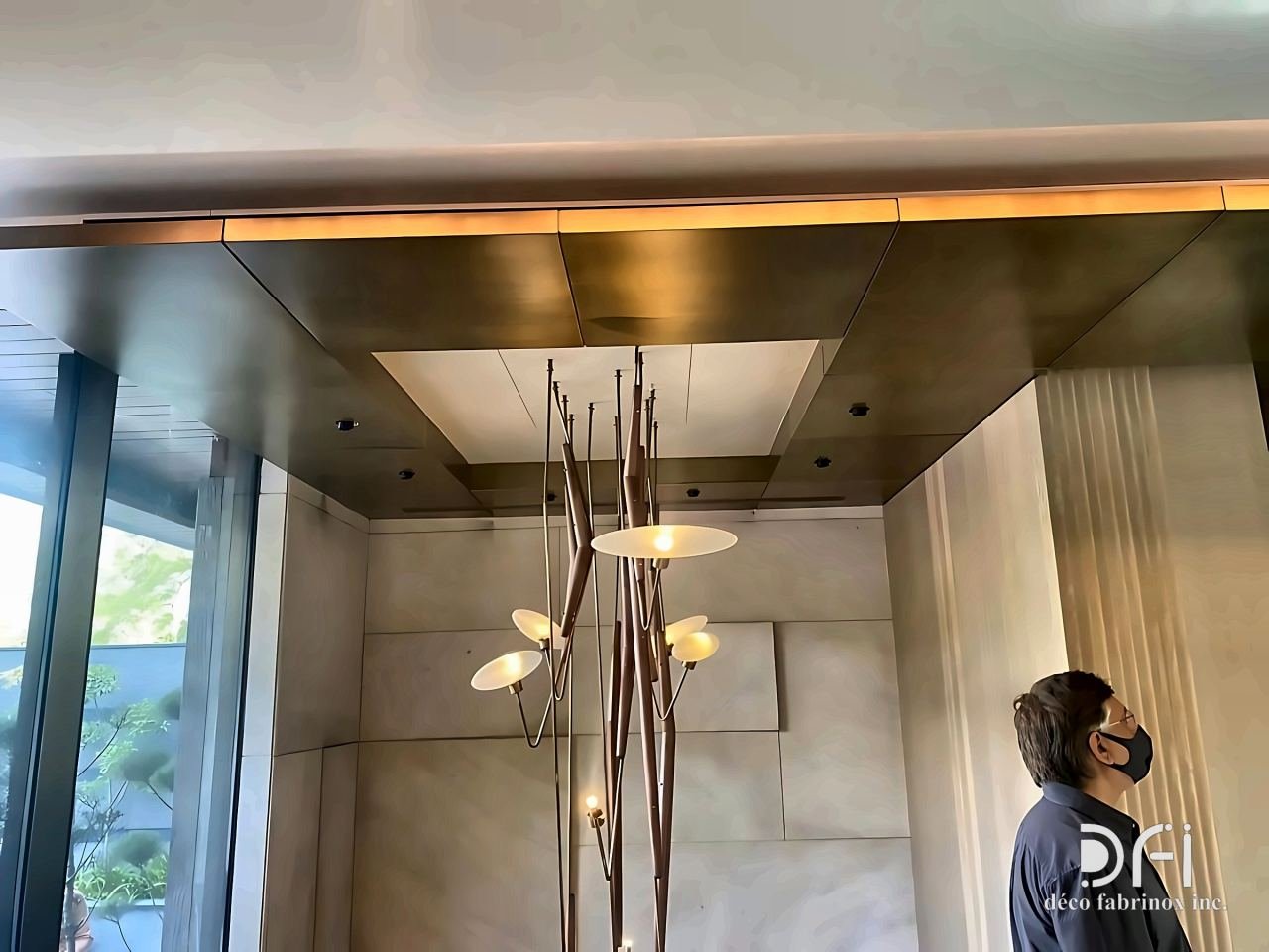 Brushed bronze ceiling coffer above a lobby chandelier