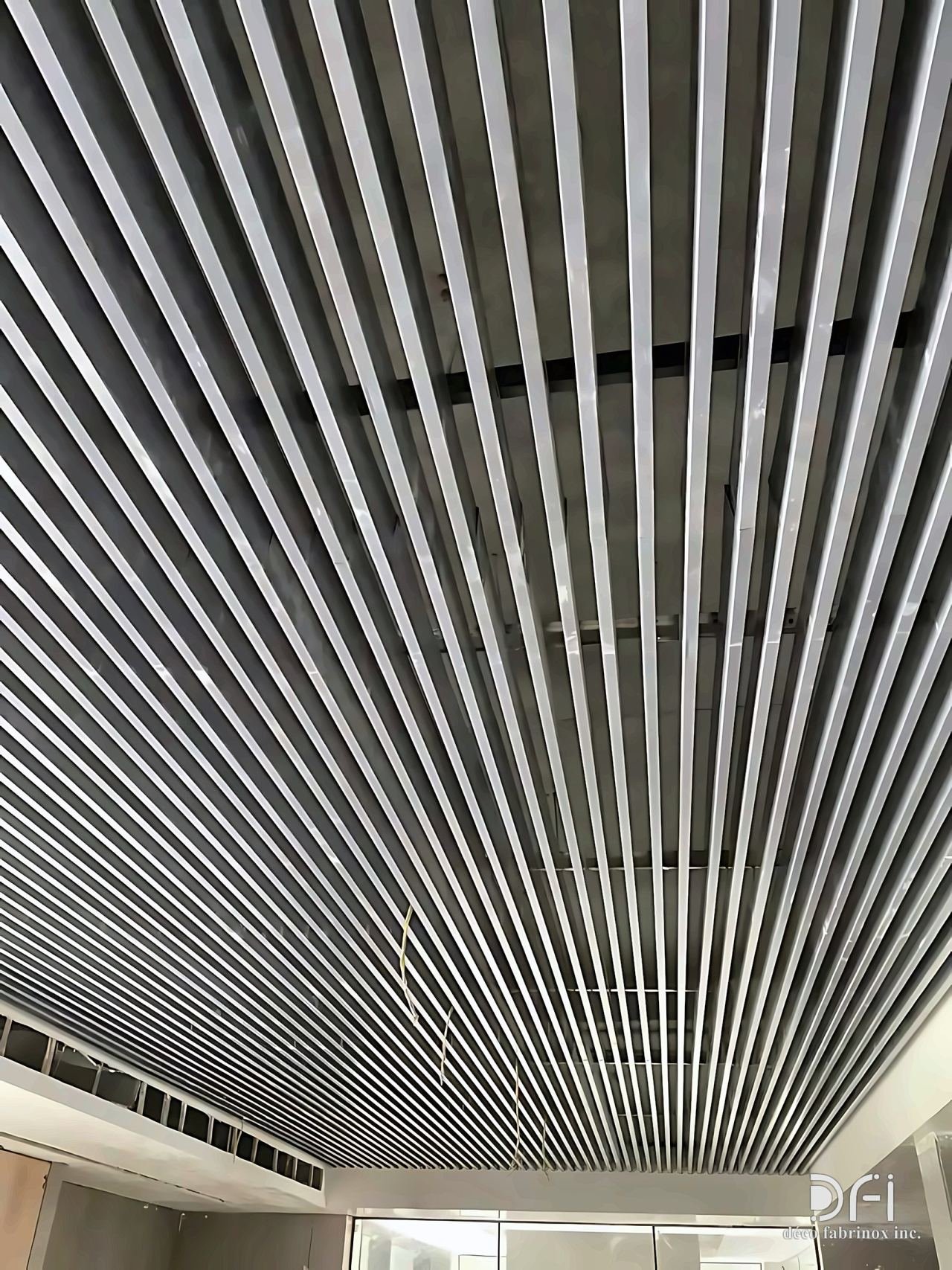 Silver metal baffle ceiling of long parallel slats