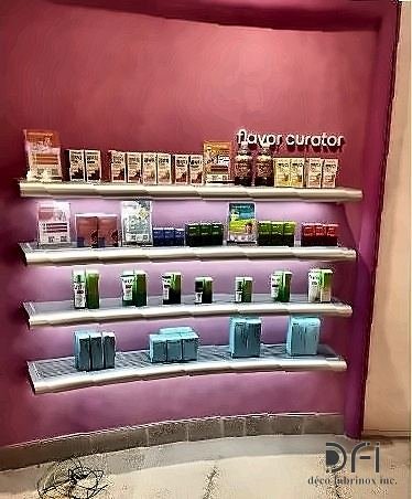 Slim metal display shelving fixed to a retail feature wall