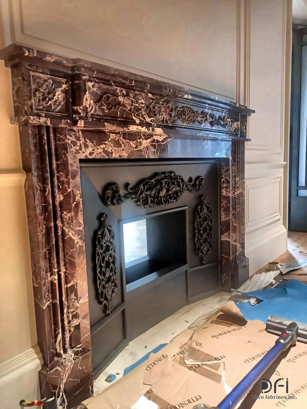 Blackened metal fireplace surround with scrollwork, in a marble mantel
