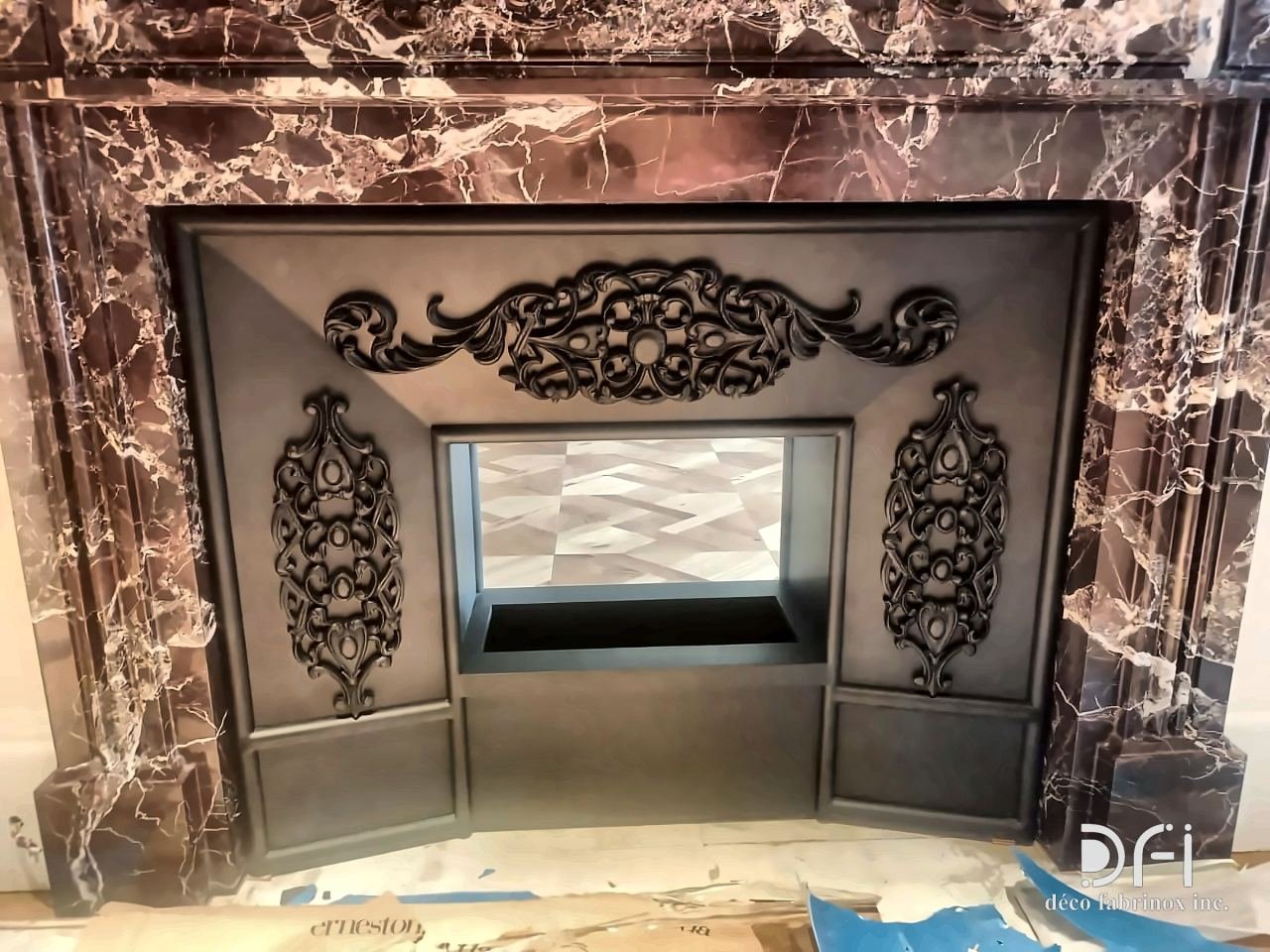 Close view of a blackened fireplace insert with scrolled ornaments