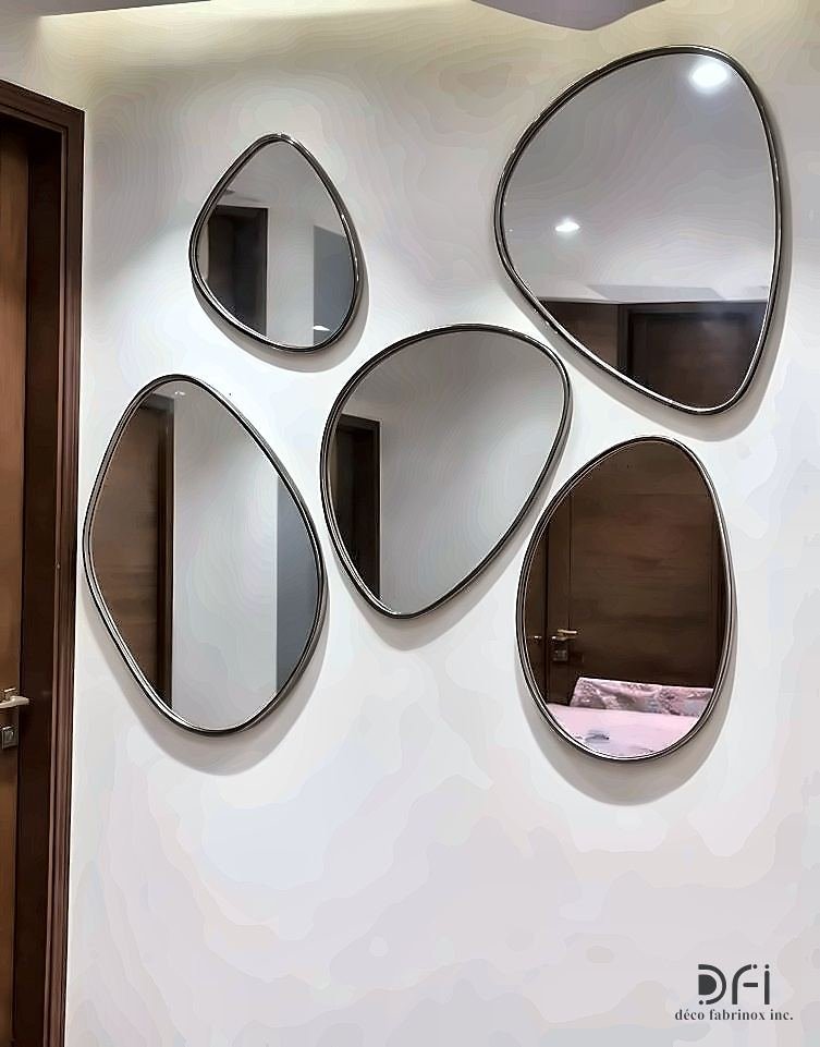 Cluster of pebble-shaped metal-framed mirrors on a wall