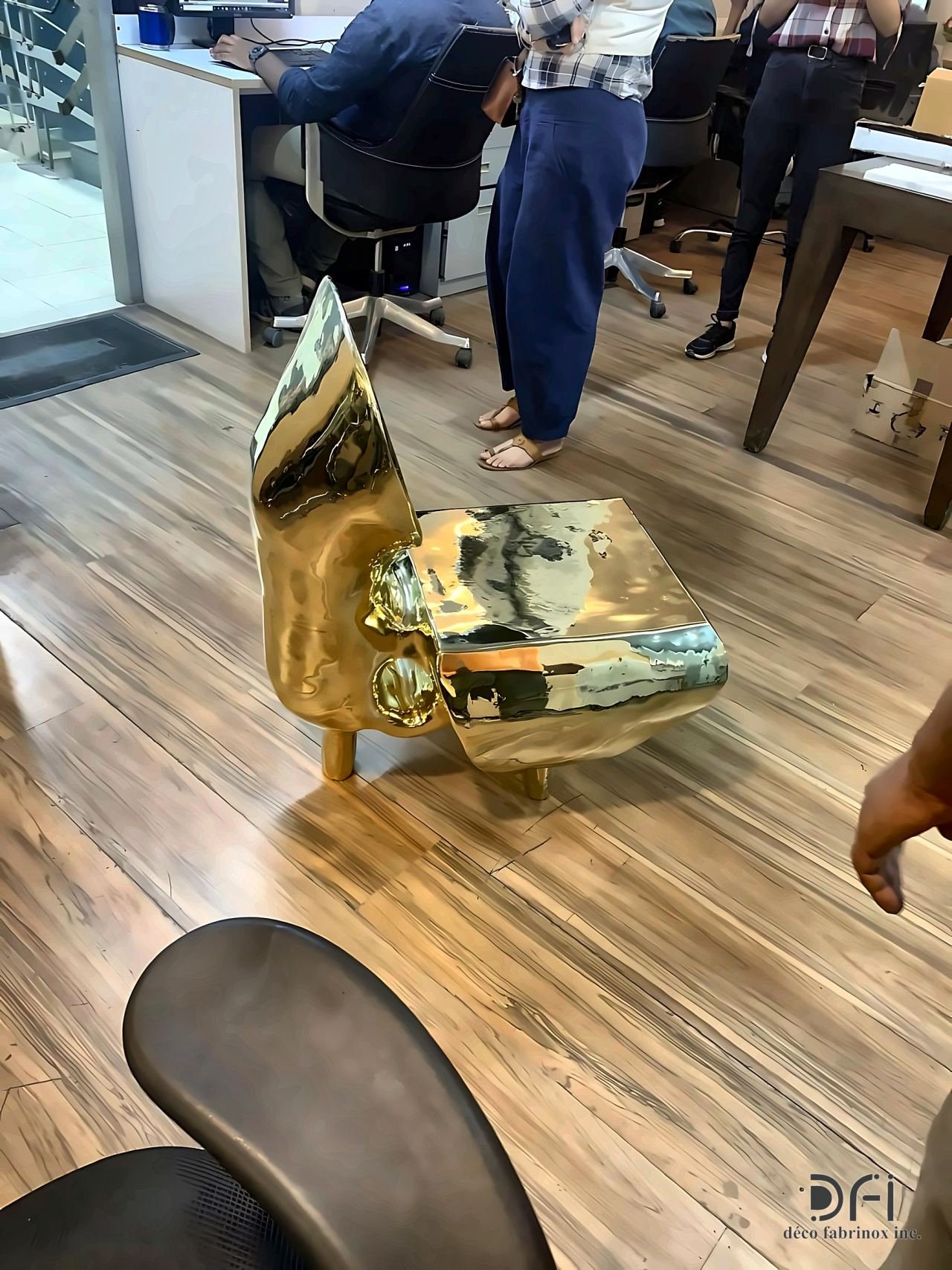 Polished gold sculptural side table on a timber floor