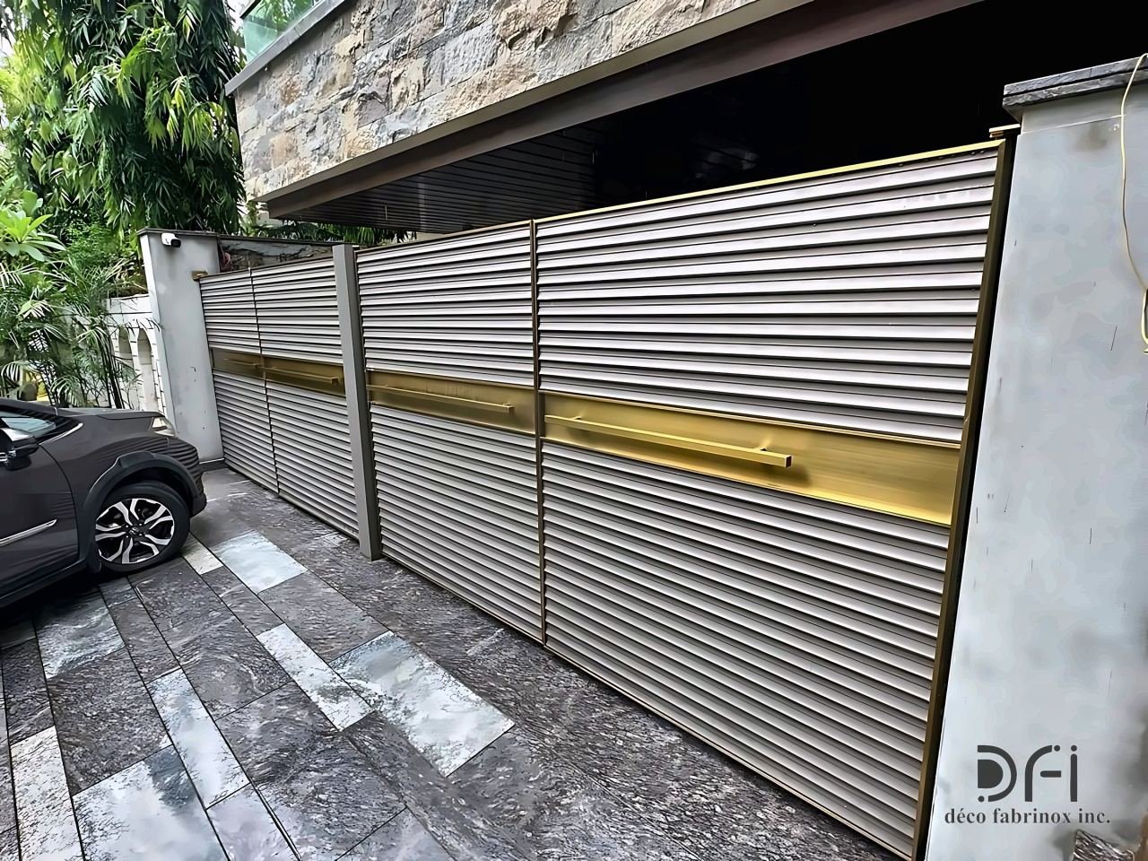 Louvred gate panels with brass bands along a driveway