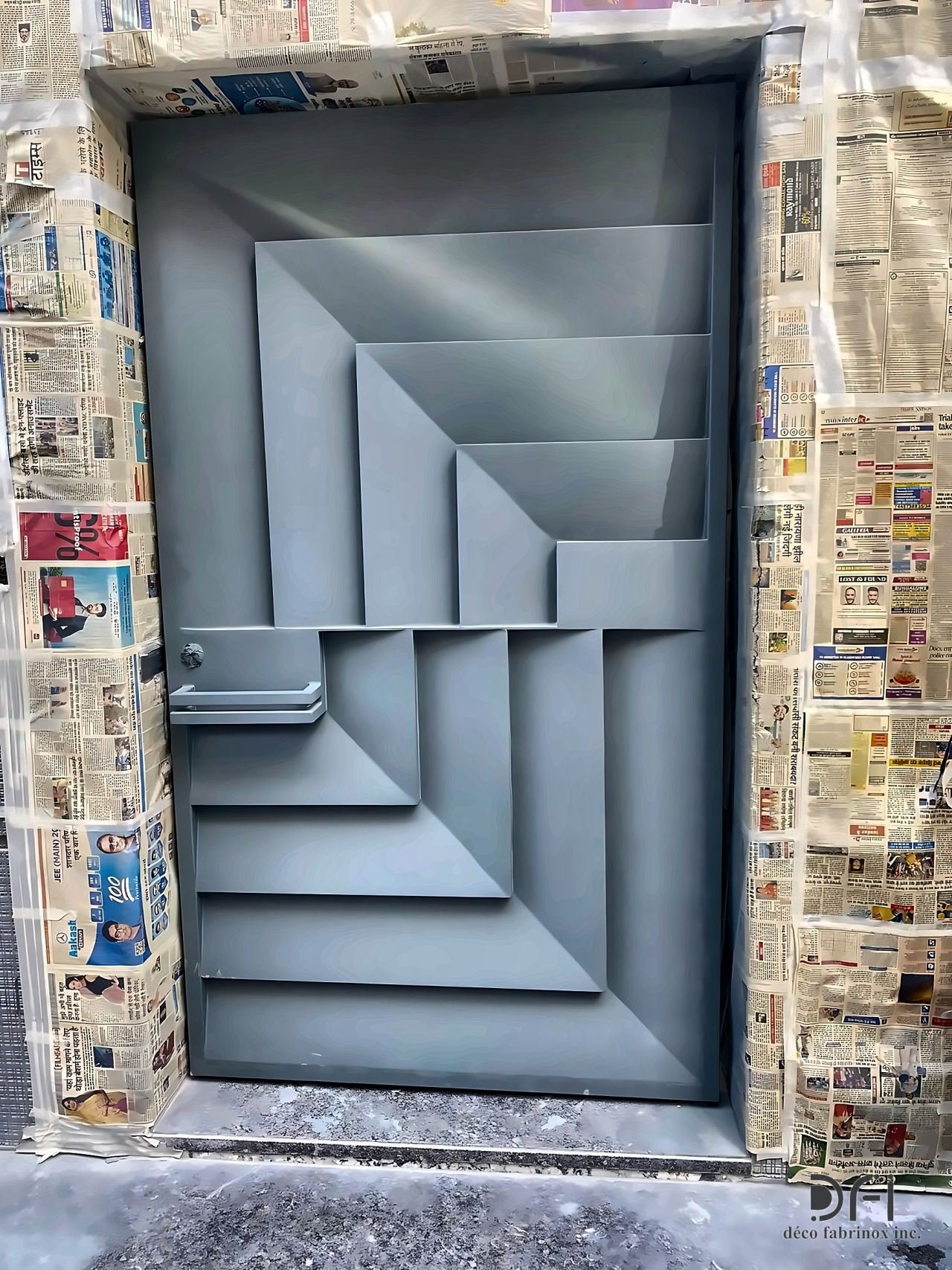 Grey faceted metal door with stepped relief during installation