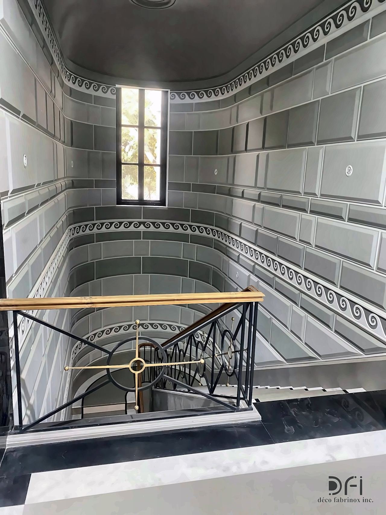 Black metal balustrade with a brass handrail at a stair void