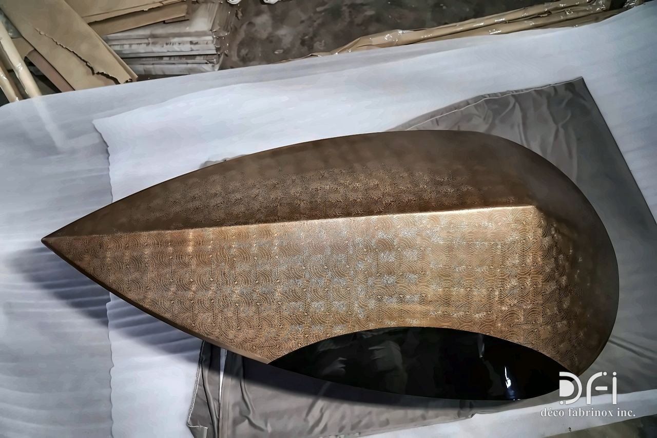 Textured bronze leaf-shaped sculpture in the workshop