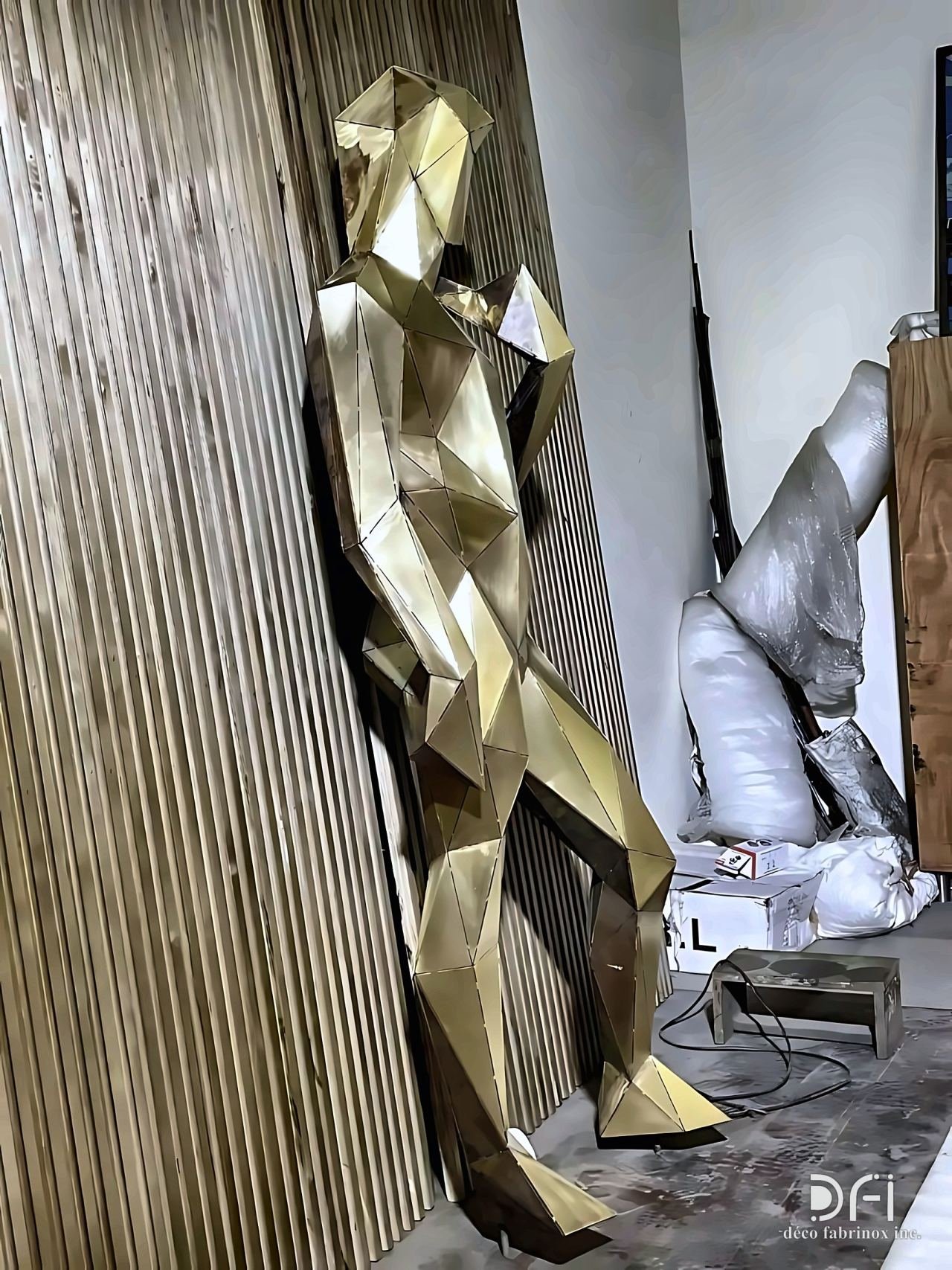 Faceted gold human figure sculpture in the workshop