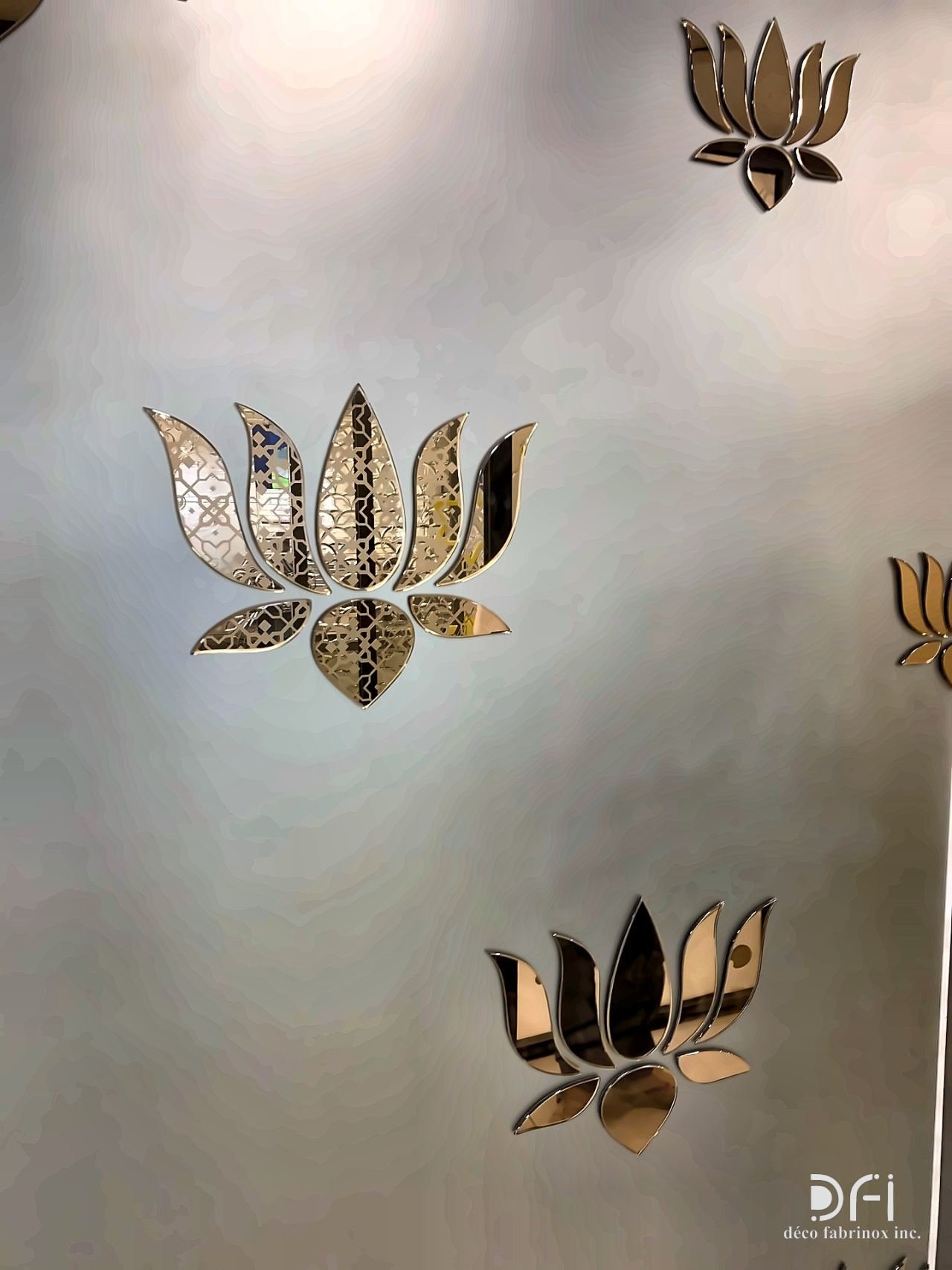 Laser-cut brass lotus motifs on a metal wall