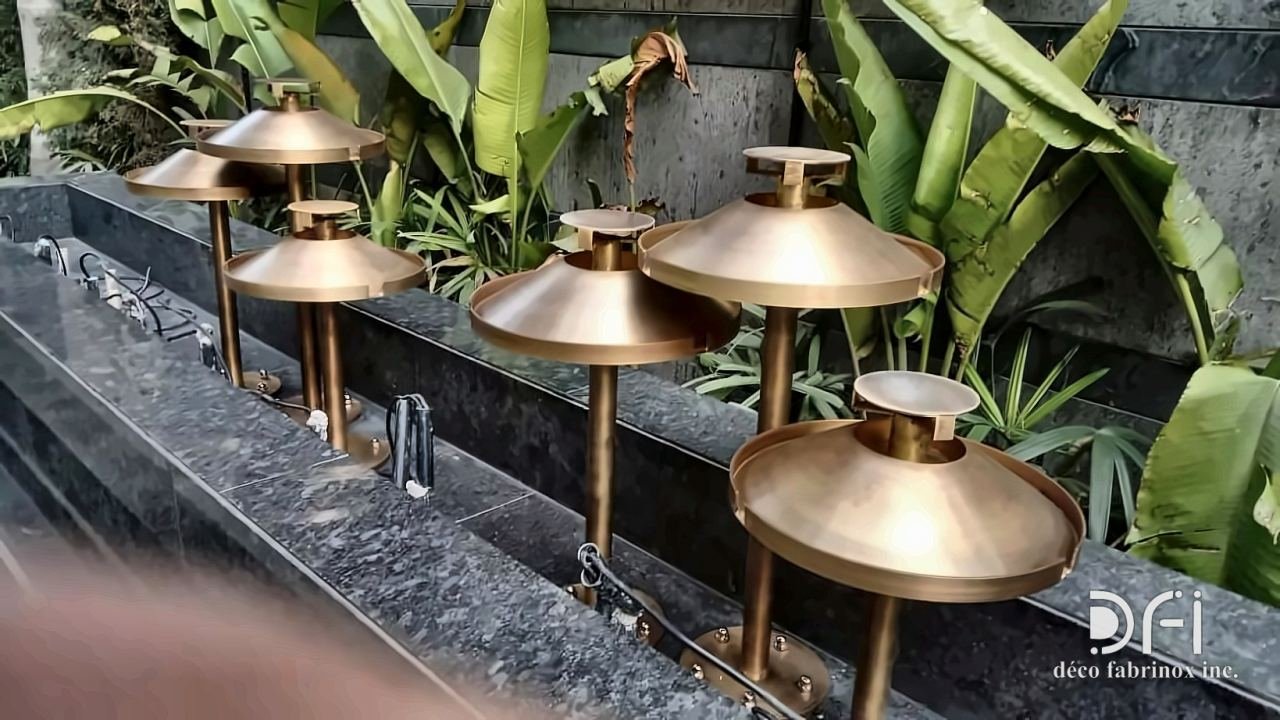 Copper lantern-shaped garden lights beside a water feature