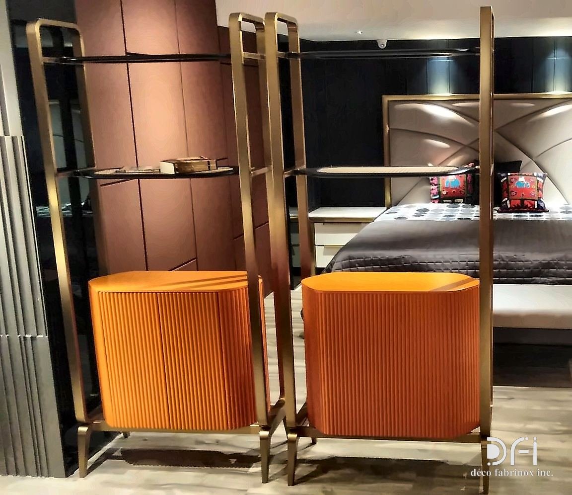 Bronze-framed shelving with orange upholstered stools in a bedroom