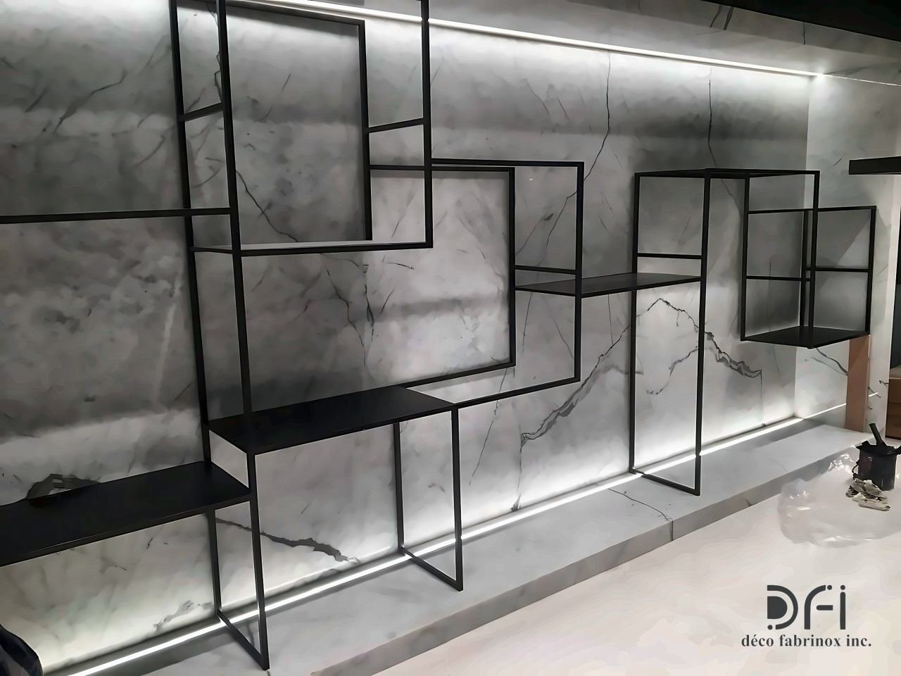 Blackened steel open shelving against a backlit marble wall