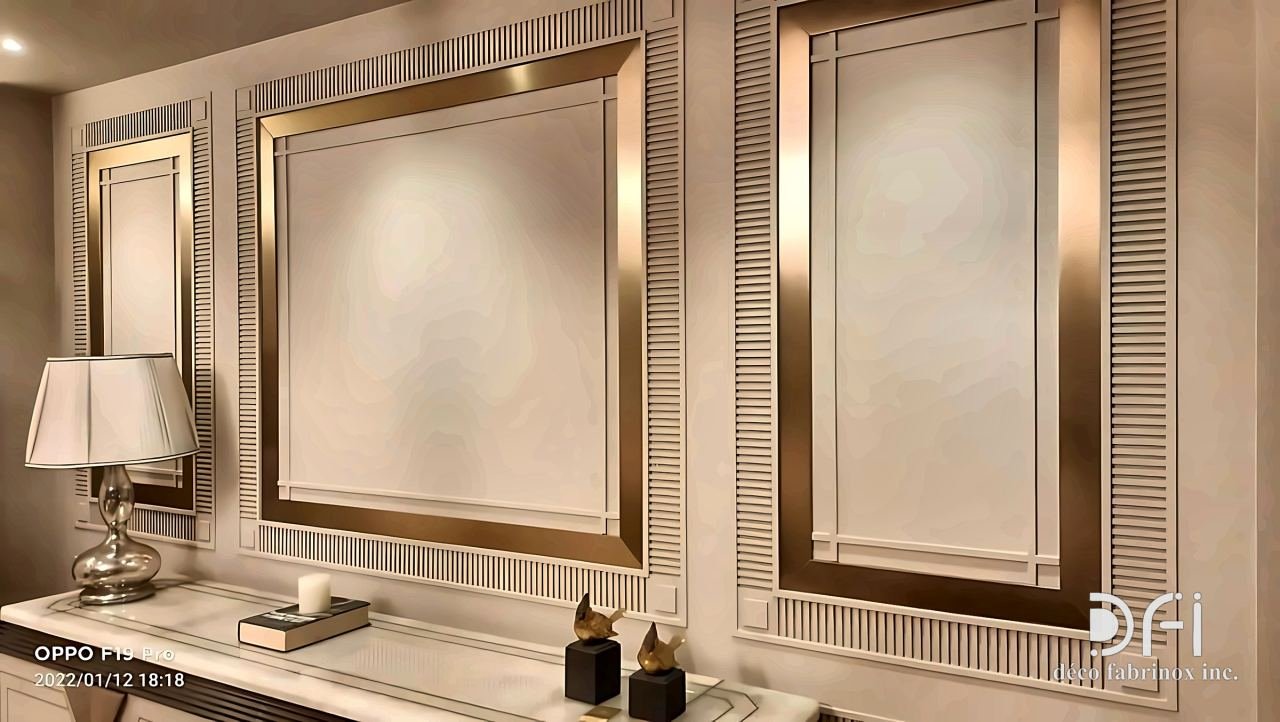 Wall panels framed in polished brass with fluted borders