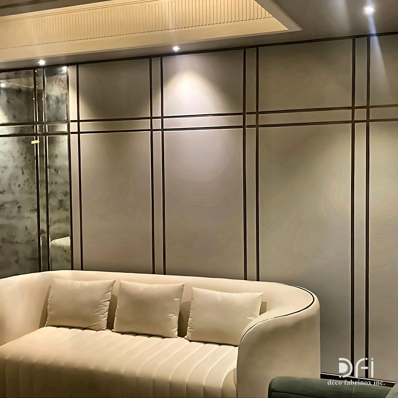 Wall panels with slim bronze inlay lines behind a sofa
