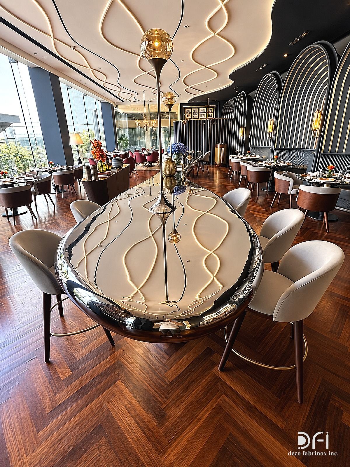 Long mirror-steel dining table under a sculpted ceiling