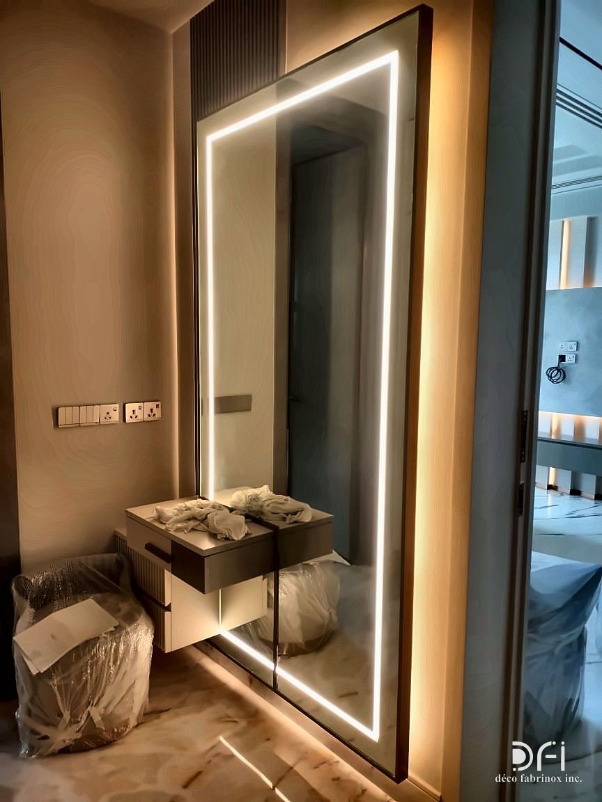 Full-height mirror framed with a line of light, in a dressing area