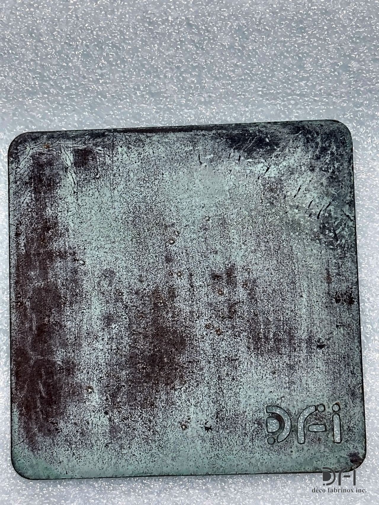 Blue-green patina sample with the DFI mark cut in