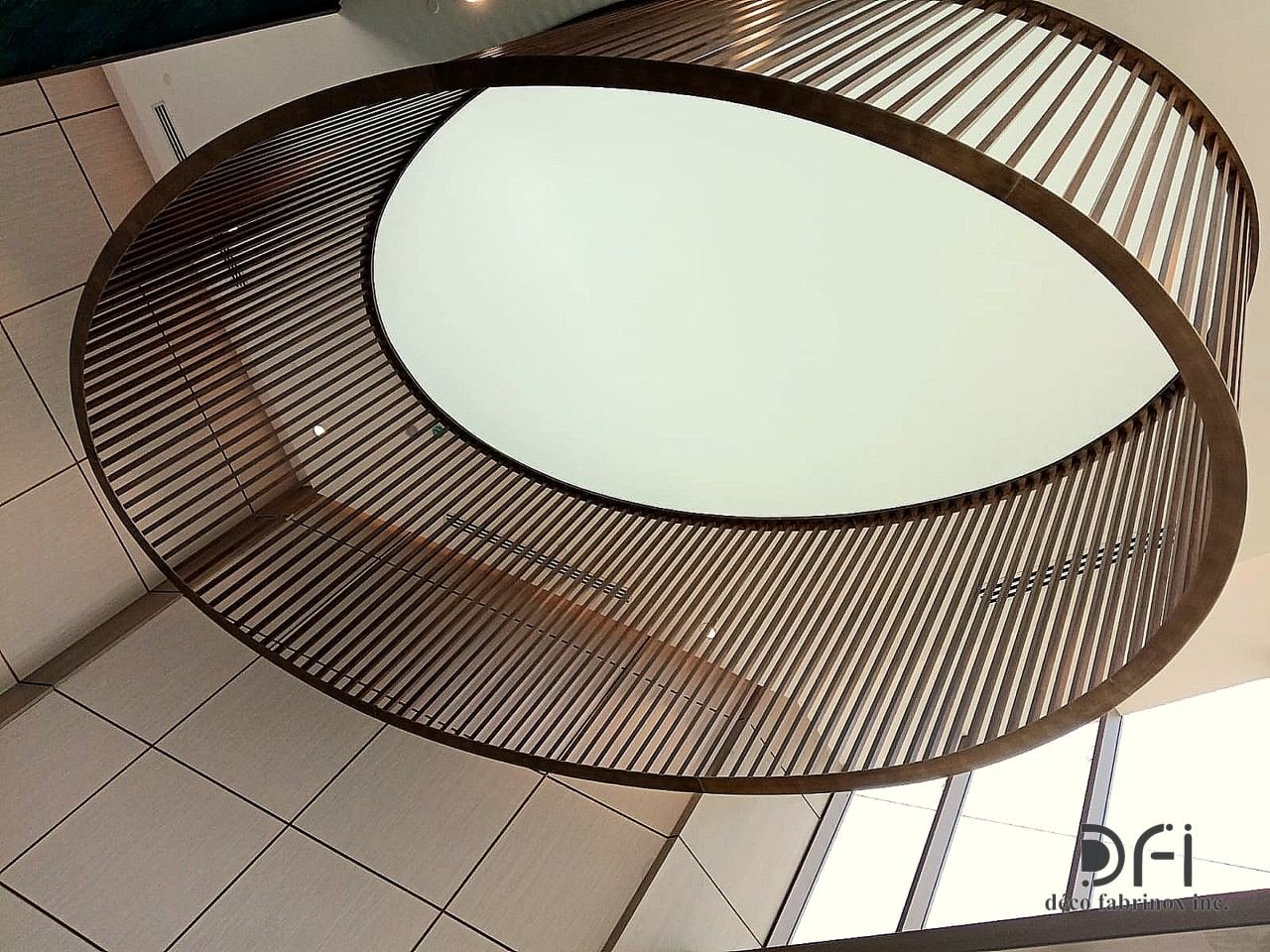 Oval slatted bronze ceiling feature over a lit panel in a developer's sales lounge