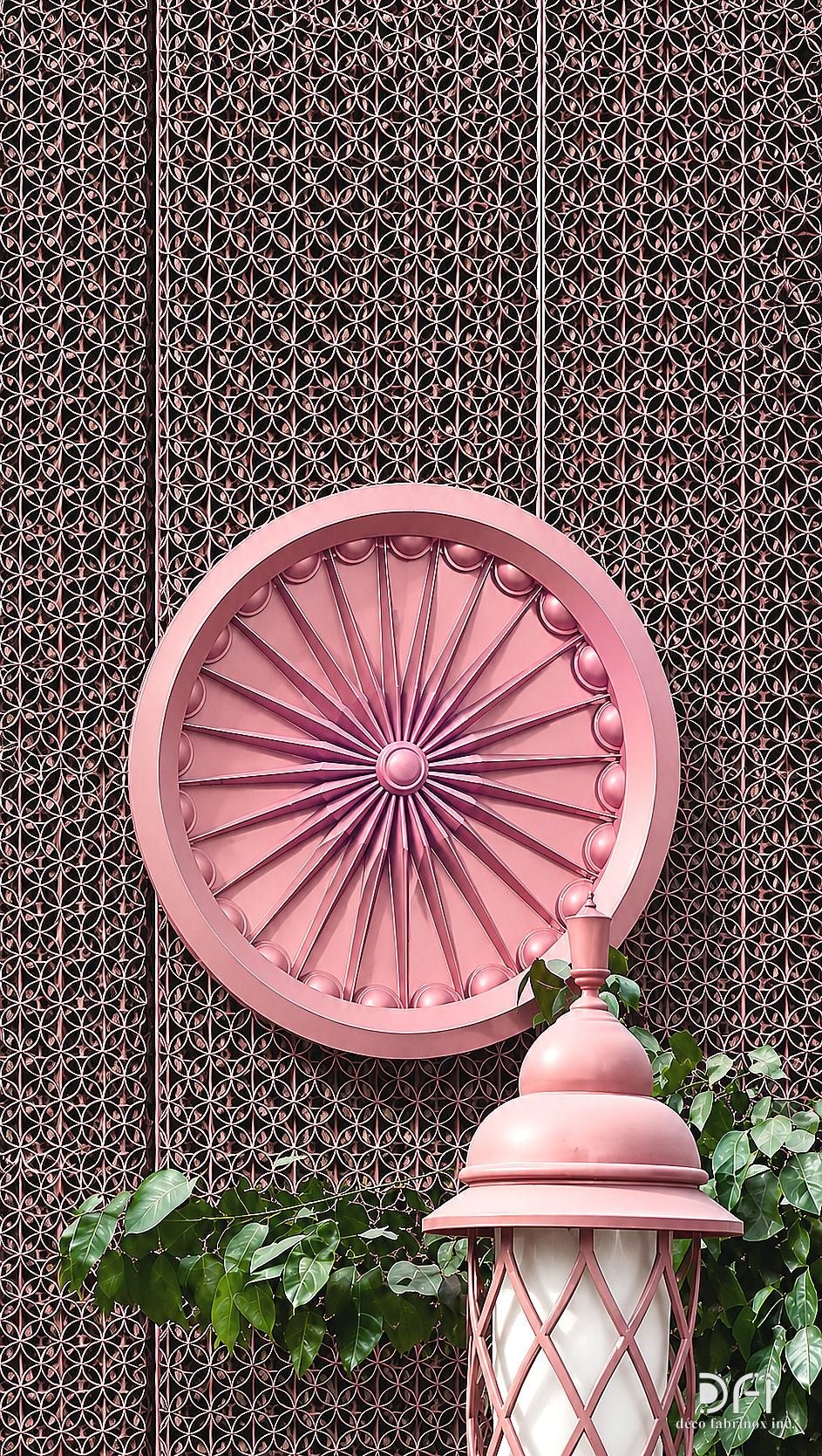 Pink metal medallion and lantern on a patterned wall