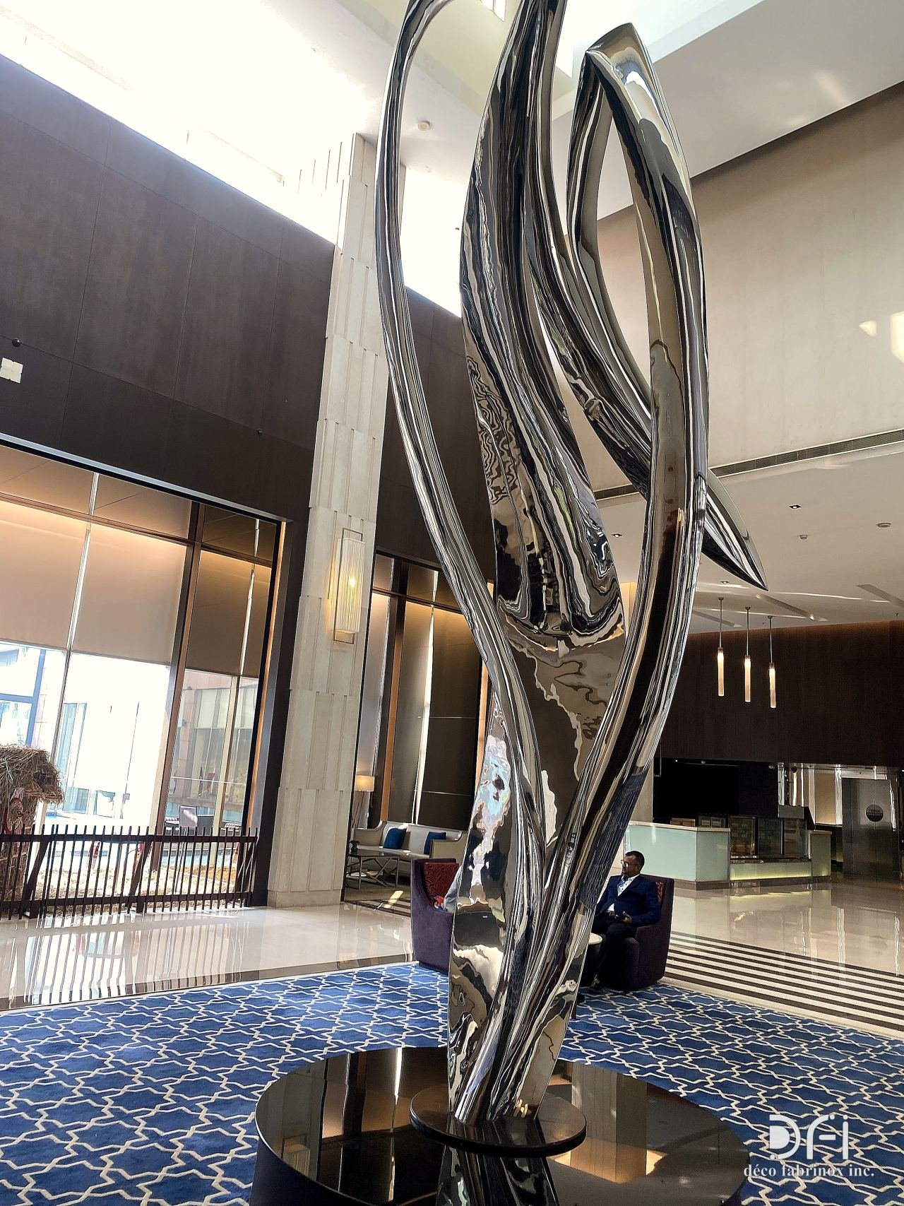 Polished steel feather sculpture in a hotel lobby