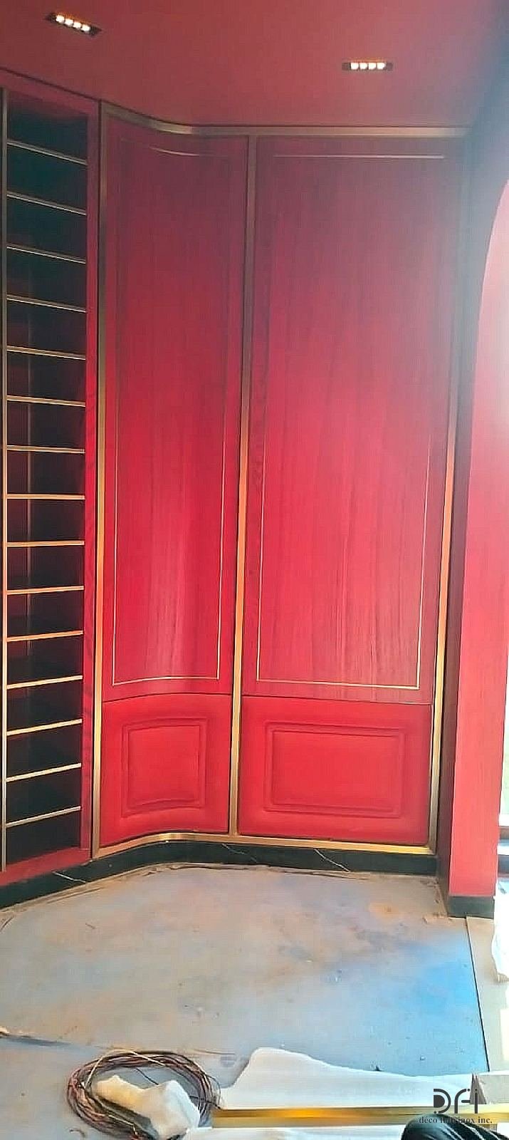 Red lacquered wall with slim brass grille panels and trims