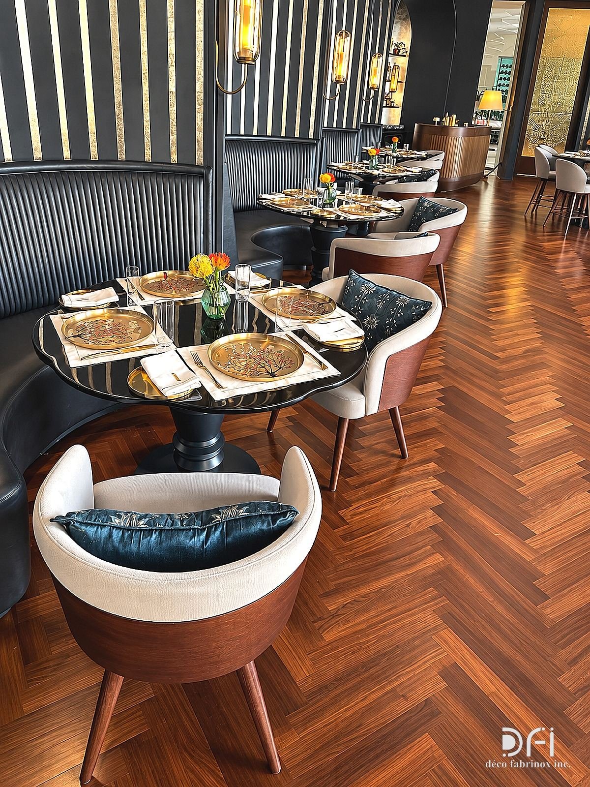 Restaurant booths with fluted metal backs and brass-edged tables