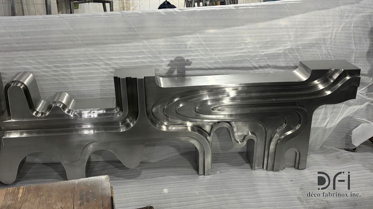 Long sculpted steel console laid out in the workshop