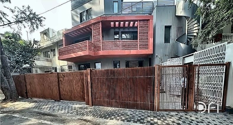 Slatted metal boundary gate and fencing outside a residence